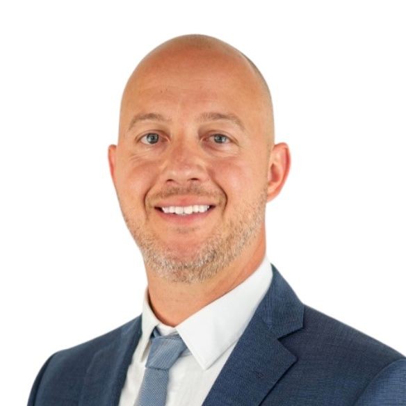 Smiling man in a blue suit and tie against a white background.